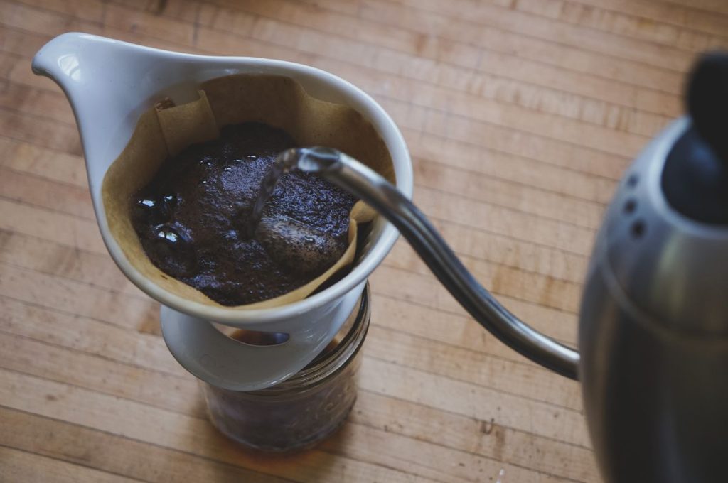Eau versée en spirale sur le café dans un dripper vue du dessus