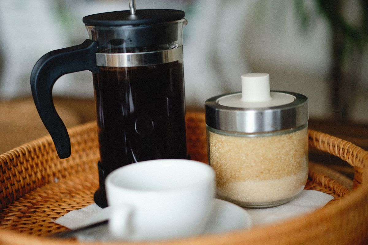 Cafetière à piston remplie de café sur un plateau