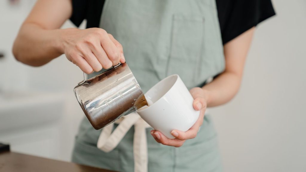 Versage de la mousse de lait depuis un pichet inox