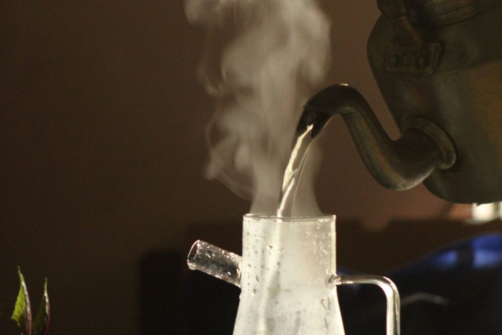 Eau chaude fumante versée d une bouilloire dans une verseuse